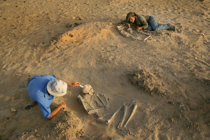 
	Paul Sereno (right) and archaeologist Elena Garcea excavate adjacent burials at Gobero
	Mike Hettwer ©2008 National Geographic

	Figure Caption: National Geographic Explorer-in-Residence Paul Sereno (right) and archaeologist Elena Garcea excavate adjacent burials at Gobero, the largest graveyard discovered to date in the Sahara. Two seasons of excavation supported by the National Geographic Society revealed some 200 graves.
	
	The site of Gobero is located on the northwestern rim of the Chad Basin in Niger, on a sea of sand dunes covering mid-Cretaceous sandstone. Discovered by paleontologists looking for dinosaur bones, Gobero is located on the tops of calcareous-fringed, and thus geologically stable, sand dunes. At the time of the human use of the dunes at Gobero, a lake surrounded the dunes.
	Paleo-Lake Gobero
	
	Called paleo-lake Gobero, this body of water was freshwater, with depths varying between 3 and 10 meters. At depths of 5 meters or more, the dune tops were inundated. But for two long periods of time, Lake Gobero and the dunes was a fairly comfortable place to live. Archaeological investigations at Gobero have revealed middens--ancient trash heaps--containing clams and the bones of large perch, turtles, hippopotamus and crocodiles, giving us a picture of what the region must have been like.
	
	The main part of the Gobero site includes perhaps as many as 200 human burials dated to two occupations. The oldest (7700-6200 BC) is called Kiffian; a second occupation (5200-2500 BC) is called Tenerean. The hunter-gatherer-fishers who lived and buried people on the sand dunes took advantage of the wetter conditions of what is now the Ténéré Desert.
	Source: National Geographic