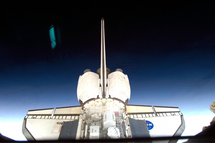 
	On flight day four of the STS-129 mission, a member of the crew photographed the aft section of space shuttle Atlantis through a window from aboard the International Space Station. Reflections on the window are visible in this image. The 11-day shuttle mission continued maintenance and upgrades to the orbital outpost.
	Date: 25 November 2009
	
	Source: NASA Image of the Day