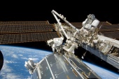 Astronauts Mike Foreman (center frame) and Randy Bresnik, STS-129, at the exterior of the ISS