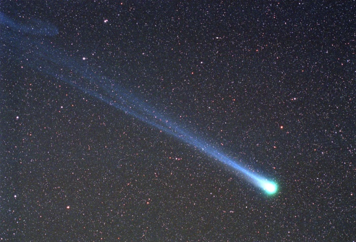 
	Comet Hyakutake Passes the Earth
	Astronomy Picture of the Day - 2009 December 16
	Credit & Copyright: Doug Zubenel (TWAN)
	
	Explanation: In 1996, an unexpectedly bright comet passed by planet Earth. Discovered less than two months before, Comet C/1996 B2 Hyakutake came within only 1/10th of the Earth-Sun distance from the Earth in late March. At that time, Comet Hyakutake, dubbed the Great Comet of 1996, became the brightest comet to grace the skies of Earth in 20 years. During its previous visit, Comet Hyakutake may well have been seen by the stone age Magdalenian culture, who 17,000 years ago were possibly among the first humans to live in tents as well as caves. Pictured above near closest approach as it appeared on 1996 March 26, the long ion and dust tails of Comet Hyakutake are visible flowing off to the left in front of a distant star field that includes both the Big and Little Dippers. On the far left, the blue ion tail appears to have recently undergone a magnetic disconnection event. On the far right, the comet's green-tinted coma obscures a dense nucleus of melting dirty ice estimated to be about 5 kilometers across. A few months later, Comet Hyakutake began its long trek back to the outer Solar System. Because of being gravitationally deflected by massive planets, Comet Hyakutake is not expected back for about 100,000 years.