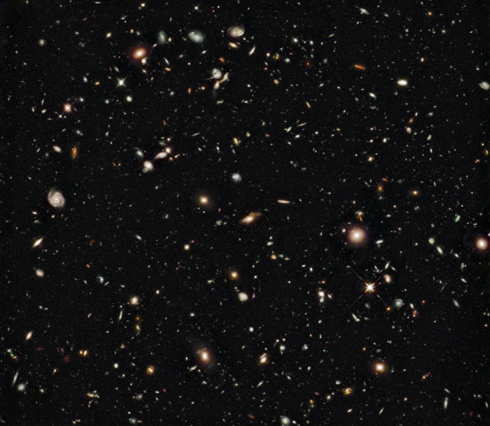
	HUDF Infrared: Dawn of the Galaxies
	Astronomy Picture of the Day - 2009 December 9
	Credit: NASA, ESA, G. Illingworth (UCO/Lick & UCSC), R. Bouwens (UCO/Lick & Leiden U.), & the HUDF09 Team
	
	Explanation: When did galaxies form? To help find out, the deepest near-infrared image of the sky ever has been taken of the same field as the optical-light Hubble Ultra Deep Field (HUDF) in 2004. The new image was taken this summer by the newly installed Wide Field Camera 3 on the refurbished Hubble Space Telescope. Faint red smudges identified on the above image likely surpass redshift 8 in distance. These galaxies therefore likely existed when the universe was only a few percent of its present age, and may well be members of the first class of galaxies. Some large modern galaxies make a colorful foreground to the distant galaxies. Analyses by the HUDF09 team indicate that at least some of these early galaxies had very little interstellar dust. This early class of low luminosity galaxies likely contained energetic stars emitting light that transformed much of the remaining normal matter in the universe from a cold gas to a hot ionized plasma.