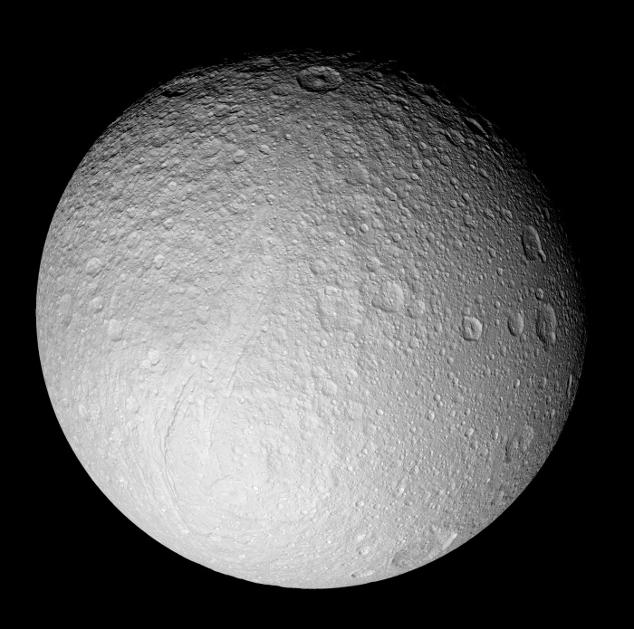 
	Ice Moon Tethys from Saturn-Orbiting Cassini
	Astronomy Picture of the Day - 2009 December 8
	Credit: Cassini Imaging Team, SSI, JPL, ESA, NASA
	
	Explanation: What processes formed the unusual surface of Saturn's moon Tethys? To help find out, NASA sent the robotic Cassini spacecraft right past the enigmatic ice moon in 2005. Pictured above is one of the highest resolution images of an entire face of Tethys yet created. The pervasive white color of Tethys is thought to be created by fresh ice particles continually falling onto the moon from Saturn's diffuse E-ring -- particles expelled by Saturn's moon Enceladus. Some of the unusual cratering patterns on Tethys remain less well understood, however. Close inspection of the above image of Tethys' south pole will reveal a great rift running diagonally down from the middle: Ithaca Chasma. A leading theory for the creation of this great canyon is anchored in the tremendous moon-wide surface cracking that likely occurred when Tethys' internal oceans froze. If so, Tethys may once have harbored internal oceans, possibly similar to the underground oceans some hypothesize to exist under the surface of Enceladus today. Might ancient life be frozen down there?