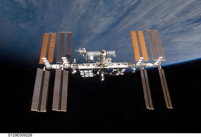 
	The International Space Station Over the Horizon
	Astronomy Picture of the Day - 2009 December 7
	Credit: STS-129 Crew, Expedition 21 Crew, NASA
	
	Explanation: This was home. Just over a week ago, the STS-129 crew of the Space Shuttle Atlantis undocked from the International Space Station (ISS) and returned to Earth. As the shuttle departed the space station, they took the above image. Visible on the ISS are numerous modules, trusses, and long wing-like solar panels. The space shuttle crew spent almost 12 days calling the space station home. The shuttle crew resupplied the space station and delivered valuable spare parts. The ISS continues to be home for five astronauts of Expedition 21. The ISS's crew now includes astronauts representing NASA, the European Space Agency, the Russian Federal Space Agency, and the Canadian Space Agency.