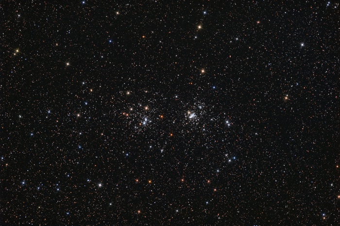 
	The Double Cluster
	Astronomy Picture of the Day - 2009 December 4
	Credit & Copyright: Neil Fleming
	
	Explanation: A lovely starfield in the heroic northern constellation Perseus holds this famous pair of open or galactic star clusters, h and Chi Perseii. Also cataloged as NGC 869 (right) and NGC 884, both clusters are about 7,000 light-years away and contain stars much younger and hotter than the Sun. Separated by only a few hundred light-years, the clusters' ages based on their individual stars are similar - evidence that they were likely a product of the same star-forming region. Always a rewarding sight in binoculars, the Double Cluster is even visible to the unaided eye from dark locations. Star colors (and spikes) are enhanced in this beautiful, wide field, telescopic image.