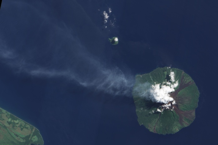 
	Manam Volcano Eruption Plume, Papua New Guinea (2009)
	
	Bright white clouds hover over the volcano’s summit. Clouds often collect over peaks, but these clouds could result from water vapour released by the volcano. Slightly darker in colour, a pale blue-grey plume blows west-north-west from the summit and over the Bismarck Sea. Just 10 kilometres across, Manam is a stratovolcano composed of alternating layers of ash, lava, and rocks from prior eruptions. The circular island sports four radial valleys spaced roughly 90 degrees apart, and these valleys have historically channelled lava and pyroclastic flows—composed of hot rock, gas and ash—sometimes all the way to the coast. Evidence of earlier volcanic activity appears as rivulets of rock that interrupt the vegetation coating much of the island. Although clouds hide the summit in this image, the summit is known to support two craters devoid of vegetation.

	Source: NASA