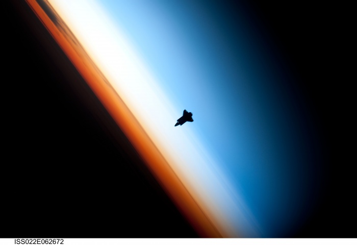 
	Dark Shuttle Approaching
	Credit: Expedition 22 Crew, NASA
	Astronomy Picture of the Day - 2010 February 16
	
	Explanation: What's that approaching? Astronauts on board the International Space Station first saw it far in the distance. Soon it enlarged to become a dark silhouette. As it came even closer, the silhouette appeared to be a spaceship. Finally, at just past 11 pm (CST) last Tuesday, the object, revealed to be the Space Shuttle Endeavor, docked as expected with the Earth-orbiting space station. Pictured above, Endeavor was imaged near Earth's horizon as it approached, where several layers of the Earth's atmosphere were visible. Directly behind the shuttle is the mesosphere, which appears blue. The atmospheric layer that appears white is the stratosphere, while the orange layer is Earth's Troposphere. This shuttle mission, which began with a dramatic night launch and will continue into next week, has many tasks planned. These tasks include the delivery of the Tranquility Module which includes a cupola bay window complex that may allow even better views of spaceships approaching and leaving the space station.