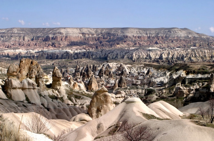 Cappadocia, a region in central w:Turkey, is known for its Göreme National Park, which was added to the w:UNESCO World Heritage List in w:1985.The first period of settlement within the region reaches to Roman period of Christian era. The area is also famous for its w:fairy chimneys w:rock formations, some of which reach 40 meters (130 feet) in height. Over thousands of years, wind and rain eroded layers of consolidated volcanic ash, or w:tuff, to form the sweeping landscape. From the 4th to 13th century AD, occupants of the area dug tunnels into the exposed rock face to build residences, stores, and churches which are home to irreplaceable Byzantine art. More than 500,000 tourists visit the region each year.