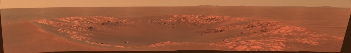    Intrepid Crater on Mars  Credit:  Mars Exploration Rover Mission, Cornell, JPL, NASA Astronomy Picture of the Day - 2010 December 8  Explanation: The robotic rover Opportunity has chanced across another small crater on Mars. Pictured above is Intrepid Crater, a 20-meter across impact basin slightly larger than Nereus Crater that Opportunity chanced across last year. The above image is in approximately true color but horizontally compressed to accommodate a wide angle panorama. Intrepid Crater was named after the lunar module Intrepid that carried Apollo 12 astronauts to Earth's Moon 41 years ago last month. Beyond Intrepid Crater and past long patches of rusty Martian desert lie peaks from the rim of large Endeavour Crater, visible on the horizon. If Opportunity can avoid ridged rocks and soft sand, it may reach Endeavour sometime next year.