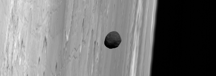    Martian Moon Phobos from Mars Express  Credit:  G. Neukum (FU Berlin) et al., Mars Express, DLR, ESA; Acknowledgement: Peter Masek Astronomy Picture of the Day - 2010 December 1  Explanation: Why is Phobos so dark? Phobos, the largest and innermost of two Martian moons, is the darkest moon in the entire Solar System. Its unusual orbit and color indicate that it may be a captured asteroid composed of a mixture of ice and dark rock. The above picture of Phobos near the limb of Mars was captured last month by the robot spacecraft Mars Express currently orbiting Mars. Phobos is a heavily cratered and barren moon, with its largest crater located on the far side. From images like this, Phobos has been determined to be covered by perhaps a meter of loose dust. Phobos orbits so close to Mars that from some places it would appear to rise and set twice a day, but from other places it would not be visible at all. Phobos' orbit around Mars is continually decaying -- it will likely break up with pieces crashing to the Martian surface in about 50 million years.