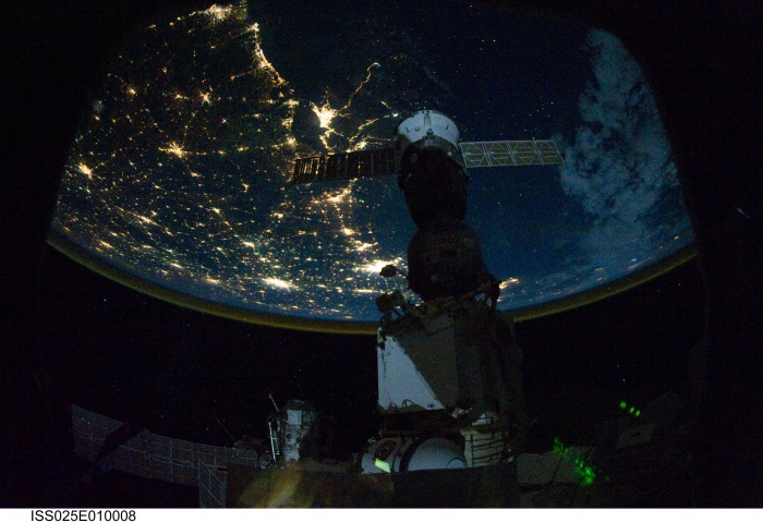   Multiverses: Night Lights  Credit: ISS Expedition 25, NASA  Astronomy Picture of the Day - 2010 November 4  Explanation: Constellations of lights sprawl across this night scene, but they don't belong in the skies of planet Earth. Instead, the view looks down from the International Space Station as it passed over the United States along the northern Gulf Coast on October 29. A Russian Soyuz spacecraft is docked in the foreground. Behind its extended solar panels, some 360 kilometers below, are the recognizable city lights of New Orleans. Looking east along the coast to the top of the frame finds Mobile, Alabama while Houston city lights stand out to the west, toward the bottom. North (left) of New Orleans, a line of lights tracing central US highway I55 connects to Jackson, Mississippi and Memphis, Tennessee. Of course, the lights follow the population centers, but not everyone lives on planet Earth all the time these days. November 2nd marked the first decade of continuous human presence in space on board the International Space Station.