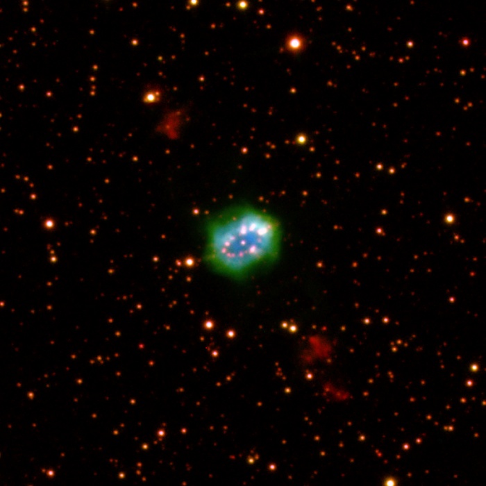    Multiverses: The Necklace Nebula  Credit: Romano Corradi (IAC), et al., IPHAS  Astronomy Picture of the Day - 2010 November 3  Explanation: The small constellation Sagitta sports this large piece of cosmic jewelry, dubbed the Necklace Nebula. The newly discovered example of a ring-shaped planetary nebula is about 15,000 light-years distant. Its bright ring with pearls of glowing gas is half a light-year across. Planetary nebulae are created by sun-like stars in a final phase of stellar evolution. But the Necklace Nebula's central star, near the center of a ring strongly tilted to our line of sight, has also been shown to be binary, a close system of two stars with an orbital period of just over a day. Astronomers estimating the apparent age of the ring to be around 5,000 years, also find more distant gas clouds perpendicular to the ring plane, seen here at the upper left and lower right. Those clouds were likely ejected about 5,000 years before the clouds forming the necklace. This false color image combines emission from ionized hydrogen in blue, oxygen in green, and nitrogen in red.