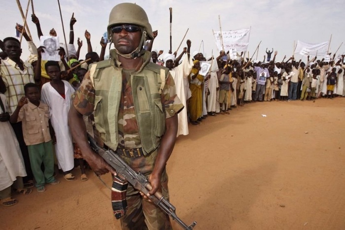 
	Darfur militia man and locals

	Source: http://www.blackagendareport.com/images/stories/142/darfur-01.jpg